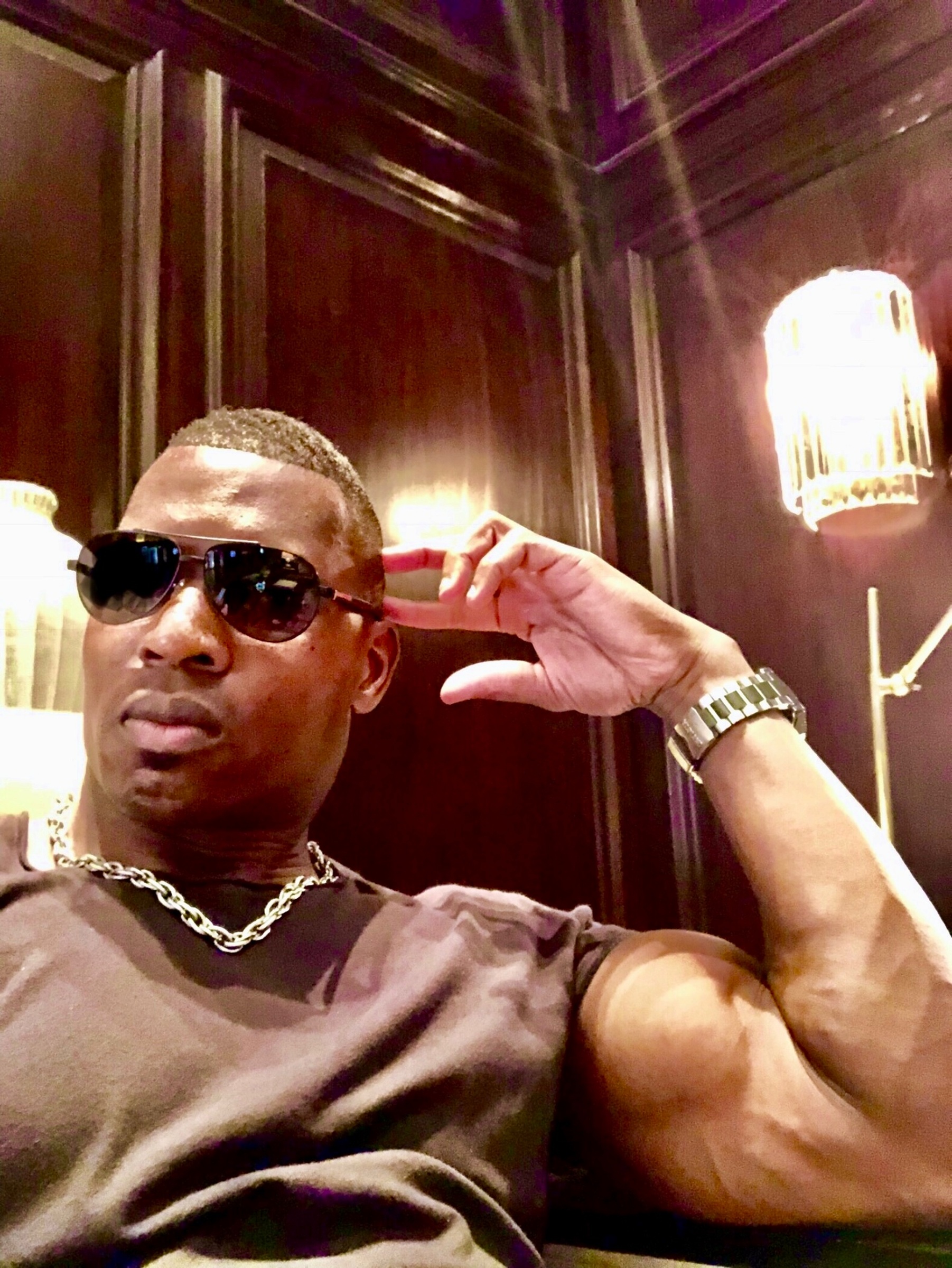 Lawrence Beamen in a wood-panelled lounge at night wearing aviators