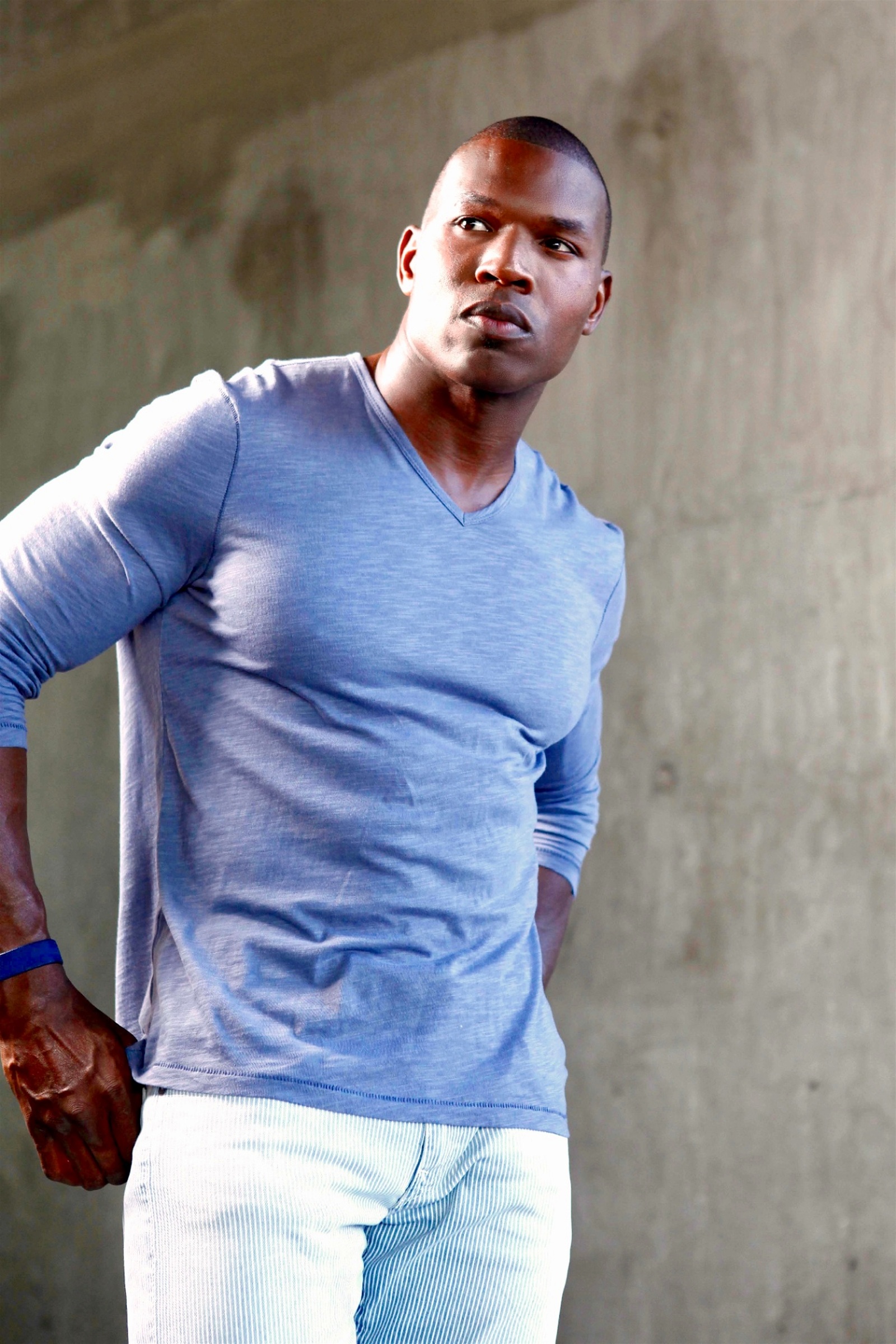 Lawrence Beamen in a blue long-sleeve tee against a concrete wall