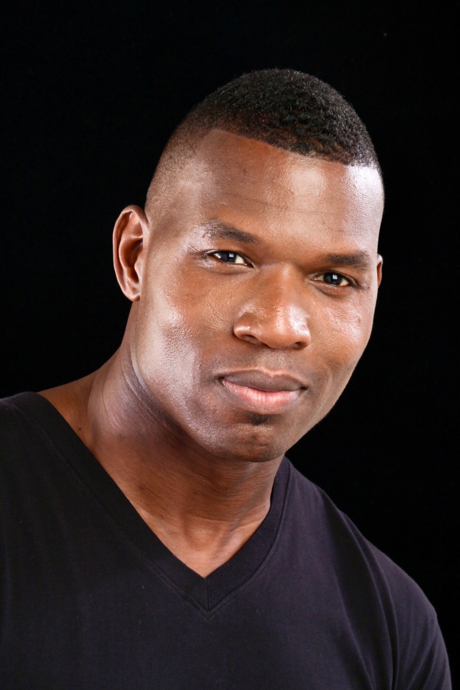Lawrence Beamen studio headshot with a slight smile on black