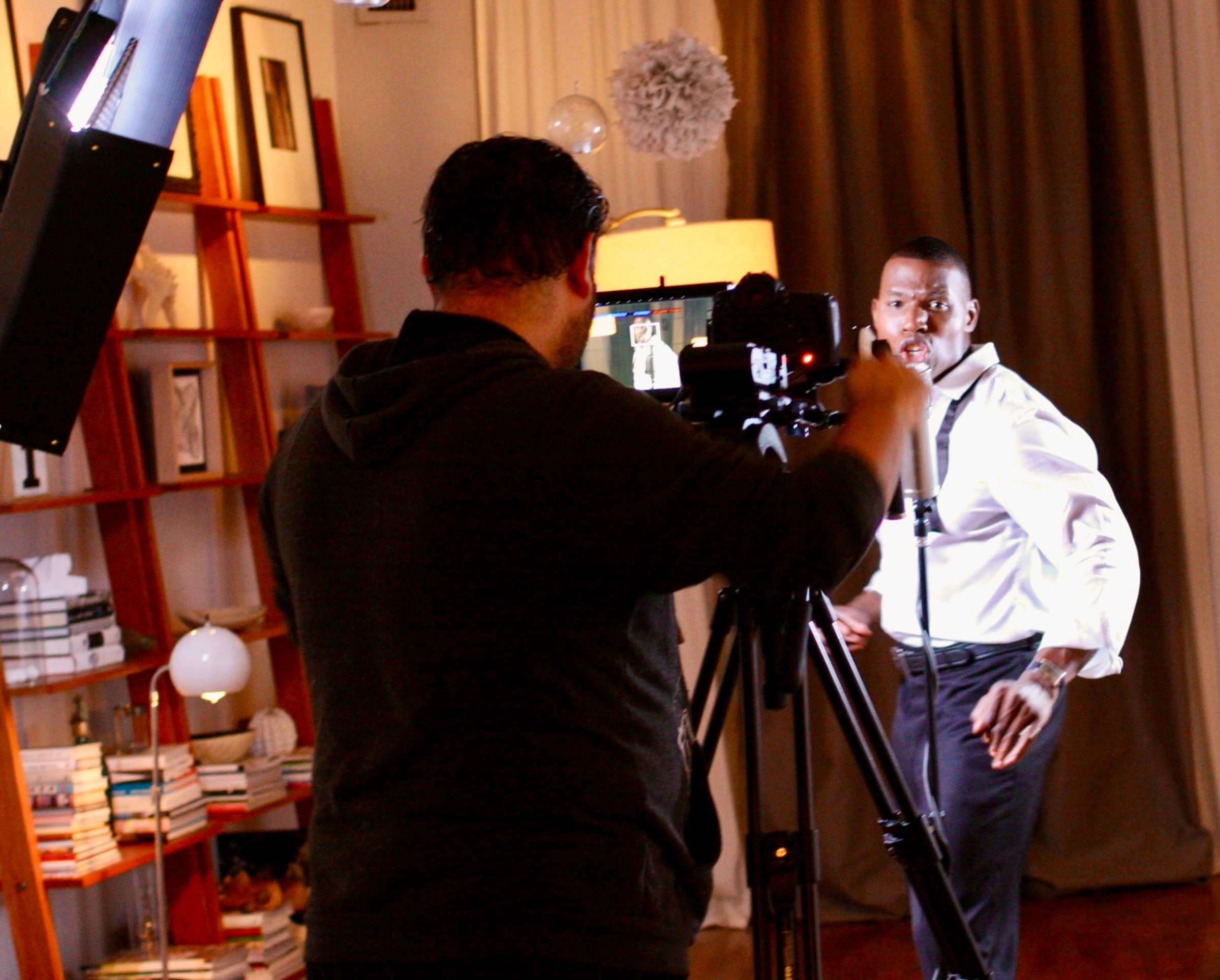 Lawrence Beamen performing to camera on a film set with crew and lights