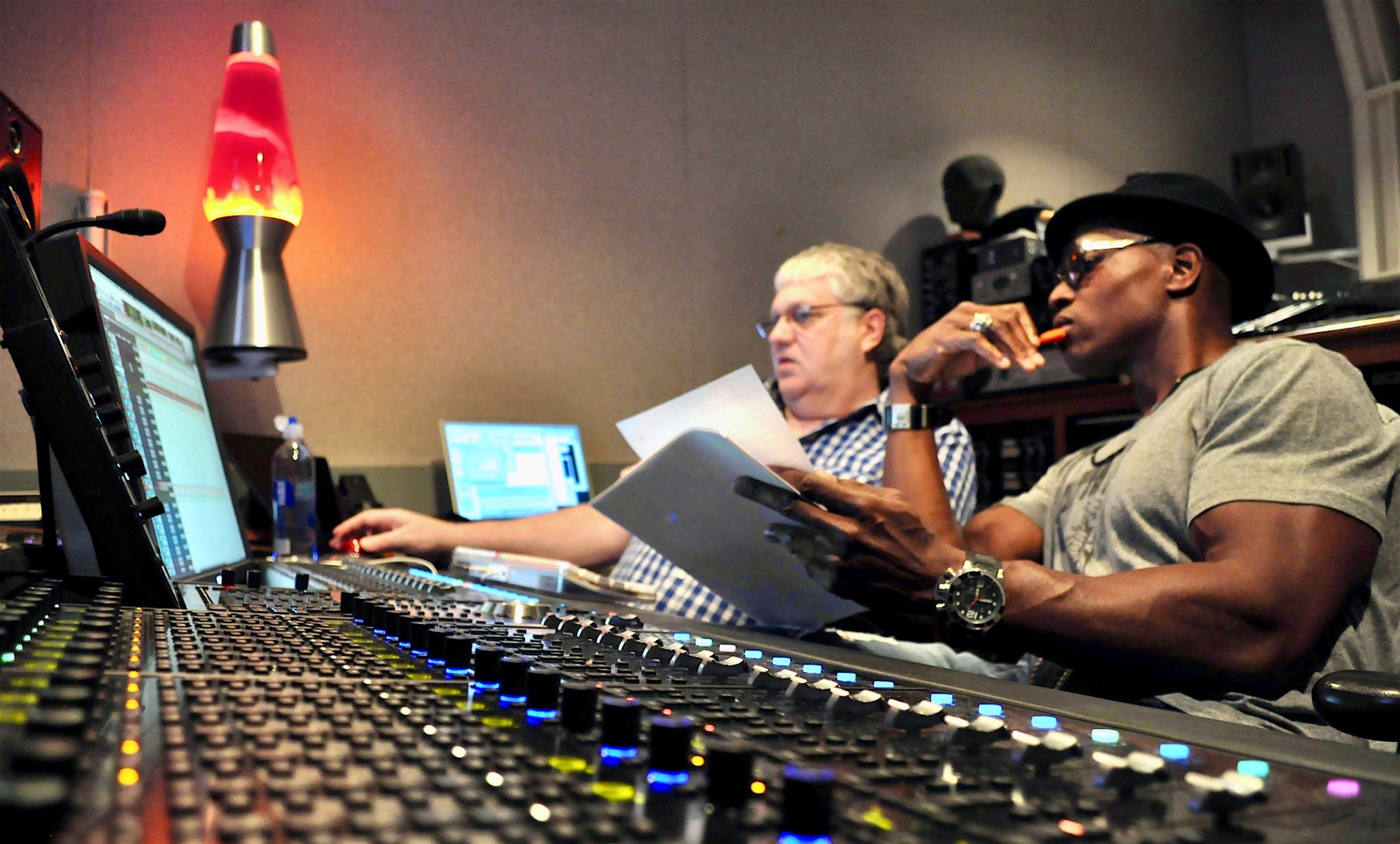 Lawrence Beamen reviewing charts at a recording console with an engineer