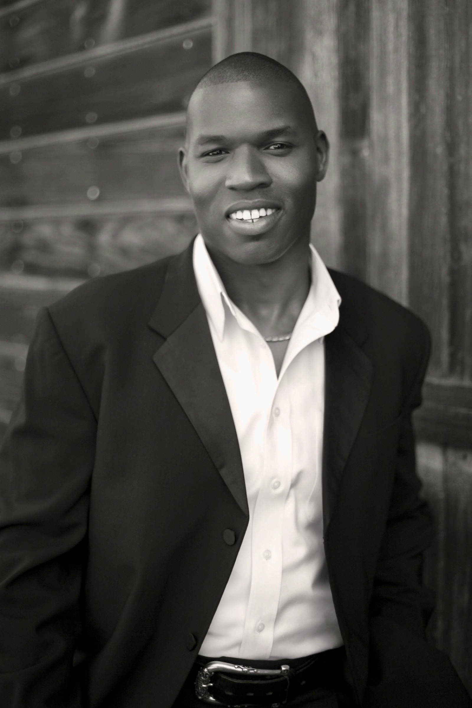 Black and white portrait of Lawrence Beamen smiling in a dark jacket and white shirt