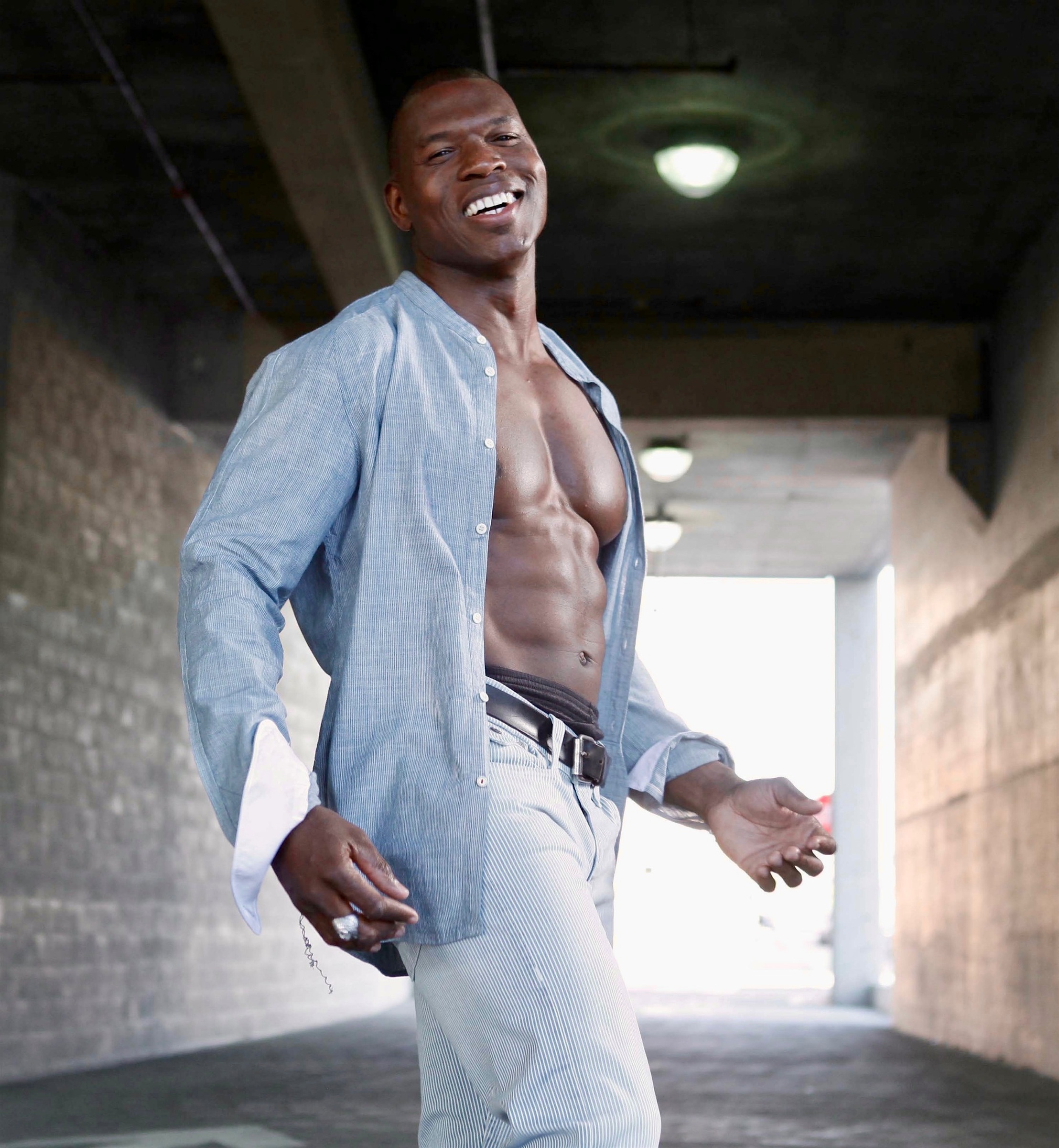 Lawrence Beamen laughing in an open linen shirt in a concrete underpass